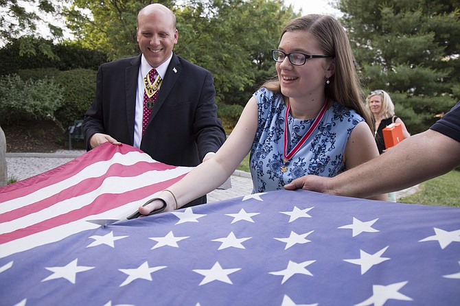 President of the Virginia Society of the Children of the American Revolution Emily Elston, 16, of Woodbridge and her father Michael Elston, president of the Virginia Society of the Sons of the American Revolution, respectfully cut a well-worn American flag to retire it from use.
