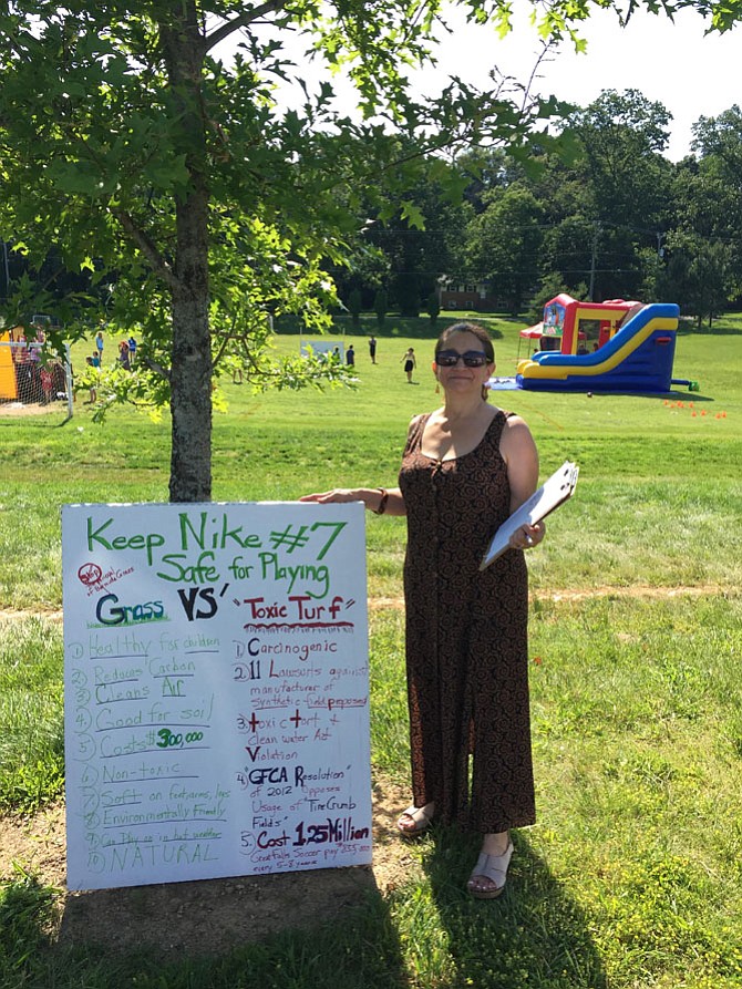 Gail Pean, mother of Vanessa Pean, protests against the turf renovation on Saturday, June 10, at the Great Falls Nike Park during a “Family Fun Day” event hosted by the Great Falls Soccer Club to benefit its fund to turf the field.