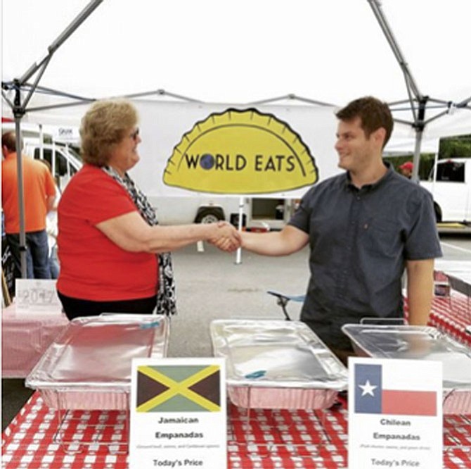 Luke Wahlgren, owner of World Eats, invites Kathleen Murphy, Great Falls Farmers Market manager, to his tent for a photo celebrating two years in his own business. Wahlgren thanks Murphy, who two years before, encouraged him to follow his dream of cooking, and his mother, Jackie Wahlgren, who supported him every step of the way. Wahlgren makes empanadas from three countries every week, all from organic ingredients, and has recently started selling from his food truck in other locations.