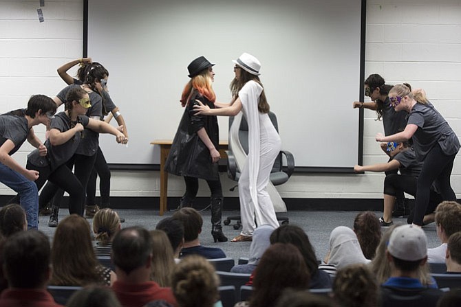 The Devil (Kaye Heintz) and Majesty (Emily Persil) get in a heated argument while the Muses provide backdrop support. 