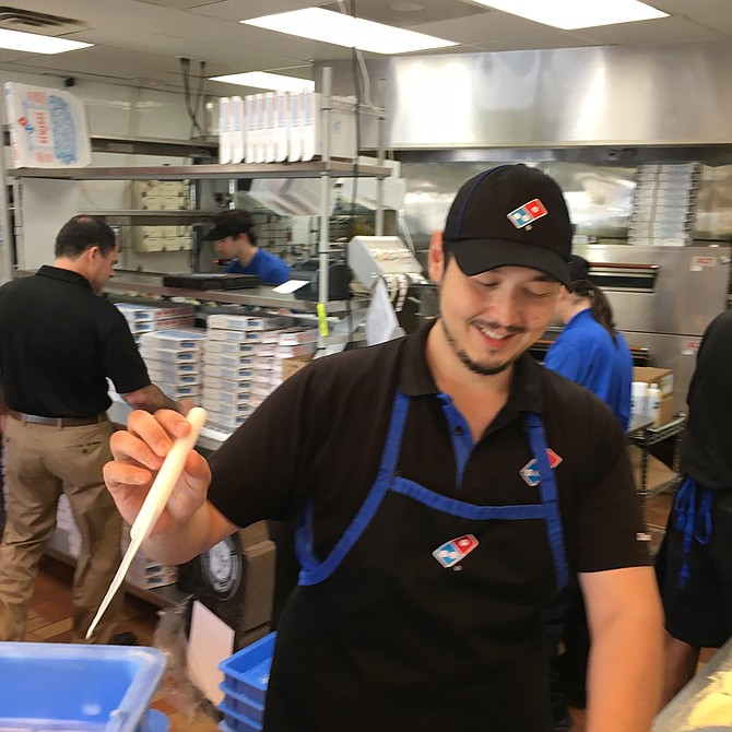 David Dixon, manager of Domino's Pizza in Potomac Oaks Shopping Center, rolls dough before making a pizza crust at the store last week.