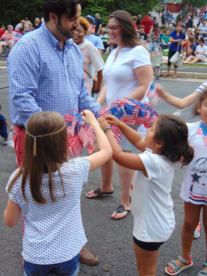 Pasha Majdi distributes American flags to the crowd at Yeonas Park in Vienna before the Fourth of July fireworks begin. 

