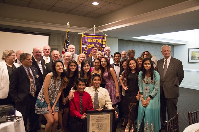 The Reston Lions Club and Herndon Community Leo Club gather for a photo with the group’s original charter, signed by its founding members in 1917.
