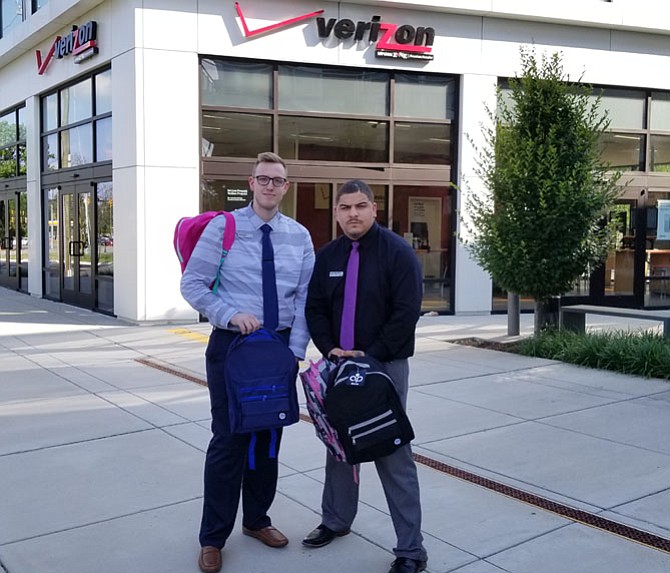 Jacob Brock and Alexander Phifer-Rogers, employees of Wireless Zone on King Street, hold backpacks that will be given away at the School Rocks Backpack Giveaway on July 23 from 11 a.m. to 4 p.m.