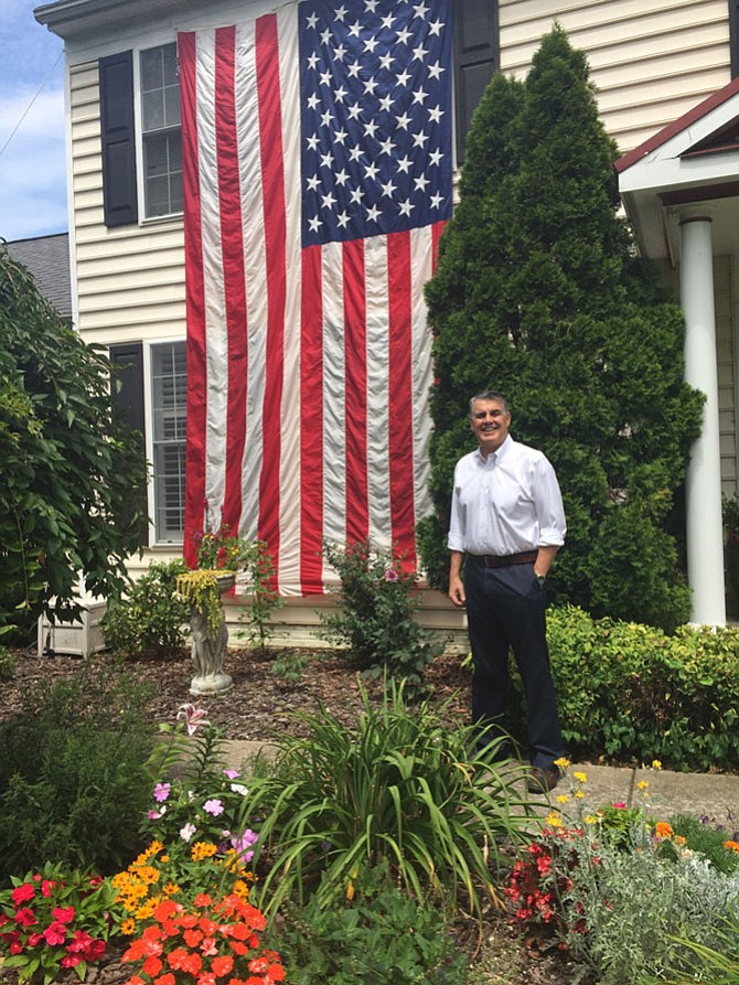 John Esposito with an American flag outside his home.