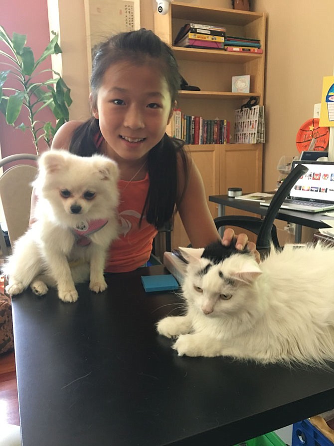 Ava Song, rising fifth grader at Great Falls Elementary School, with her pets, Fluffy the cat and Candy the dog. Fluffy was adopted from an animal shelter and has been the only pet in house for the past four years. Candy joined the family just a few weeks ago. Ava is still helping them to get along, not a very easy task.
