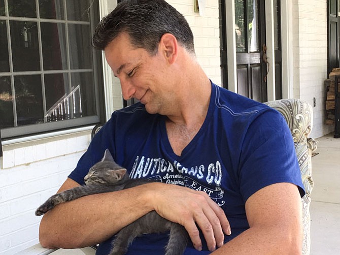 Dr. Paul Curcio of Centreville with his pet kitten, Mitzi on a "relaxing summer's day."