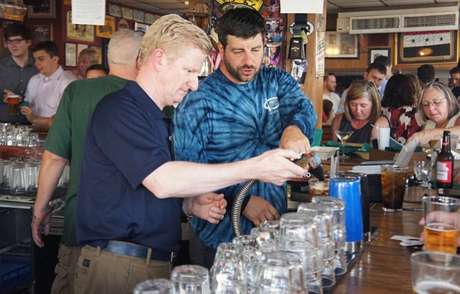 That’s how it’s done: BridgeStreet CEO Sean Worker gets a few tips from real Jimmy’s Old Town Tavern bartender Justin Fedorchak as Worker starts his “shift” as a “celebrity” bartender to help raise funds for nonprofit FISH.
