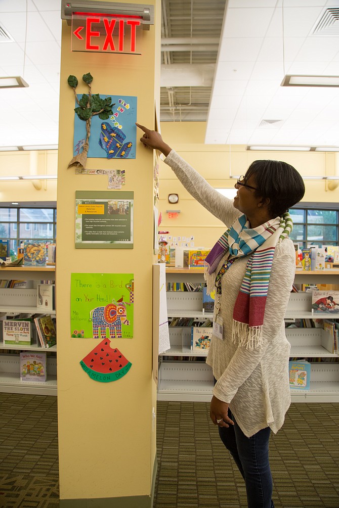 Tina Mraz, assistant branch manager at the Oakton Library points to student art work. It is part of the summer reading program’s art extension, a creative outlet unique to the Oakton Library for children to relate to the books they have read over the summer. 