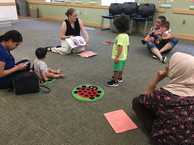 Youth Services Assistant Alexis Froyd reading to children during morning story time at the Dolley Madison Library in McLean. 