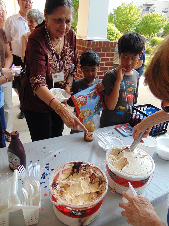 Champa Kumar and her grandchildren Neel, 8, and Ved Prakash, 5, line up for ice cream during National Night Out at the Spring Hill Community, a 55-plus senior community in Lorton, on Tuesday, Aug. 1, 2017.