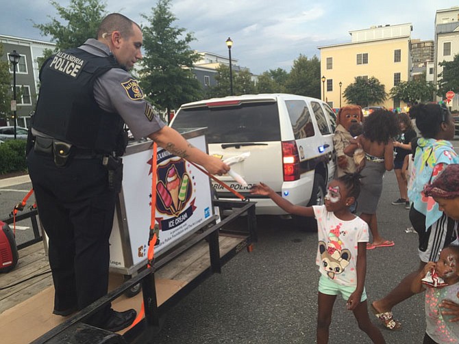 Officer Nick Ruggiero hands out ice cream near the the Charles Houston Recreation Center.