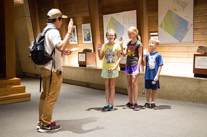 Ewan Clark, 18, a Youth Conservation Corps leader, swears in three junior members at the visitor center at Great Falls National Park on Thursday, Aug. 3.