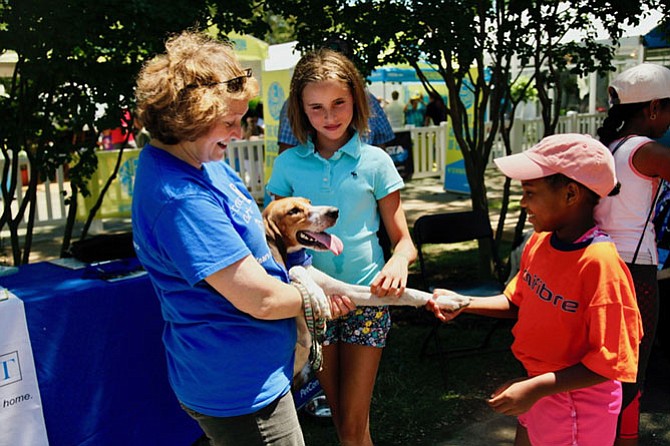 Volunteer Robin Turner brought her rescue dog with the unforgettable name of Journey. Lively, friendly, this American foxhound-mix enjoyed the crowd and shook hands with two admirers, Abby Gloekler, 11 of Annapolis and Anissa Jean-Claude, 8 who also played in the Family Day tennis clinic.