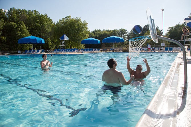 Chip Ponsart, 18, a freshman in college and a lifeguard at Greenbriar Pool Club; Ramone Nickens, 31, a Fairfax resident and Office Manager at ManTech International; and Logan Alderman, 18, a student and Fairfax resident play water basketball at Greenbriar Pool Club in Fairfax.
