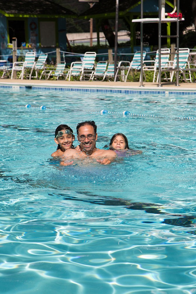 From left: Springfield residents Adam Alsaegh, 9, rising fifth grader, his father Zuhair, 49, a teacher, and Zara, 8, a third grader pose for a picture at the North Springfield Swim Club pool in Springfield.