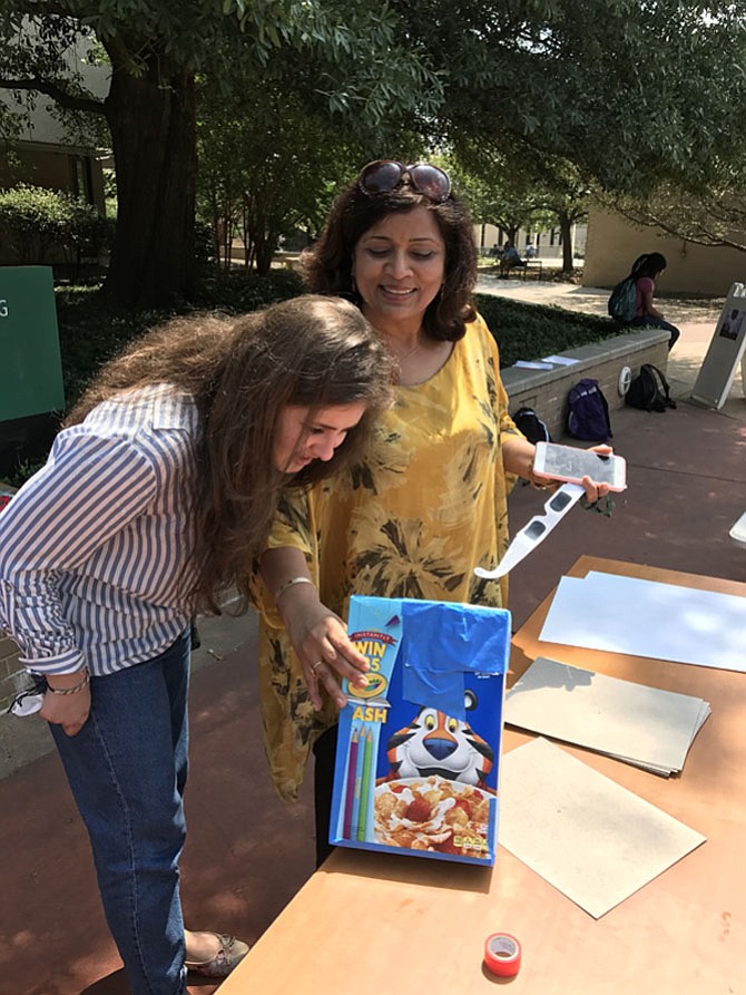 Vienna resident Ritu Kansal who teaches chemistry at NOVA’s Annandale campus demonstrates the correct way to use a pinhole viewer.
