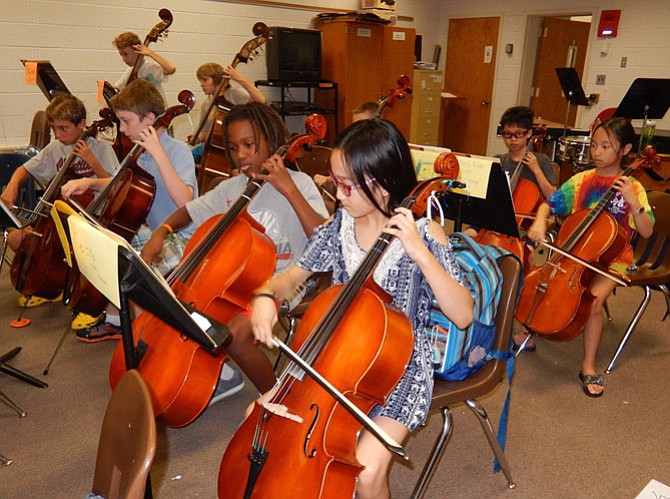 Cello players focus on their music during an intermediate-orchestra rehearsal.