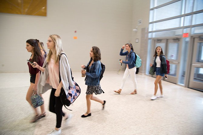 Students walk in the front doors for the first day of school for the 2017-2018 school year at Langley High School Monday morning.