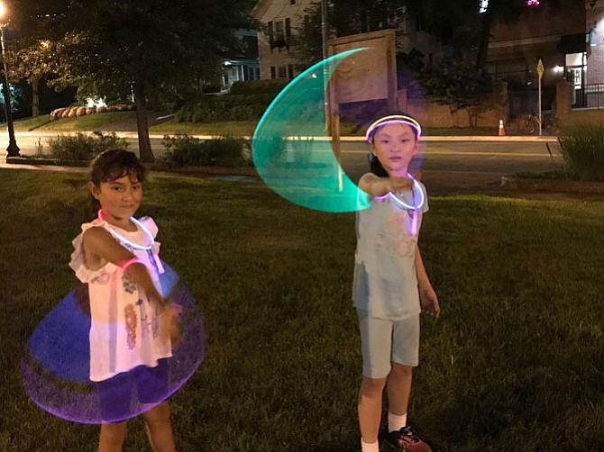 Friends Elisa Barallas, 9, and Annabelle Eggers, 9, take part in Herndon Parks and Recreation's Glow in the Dark Activity Night. "I want the night to last longer," Barallas said. 