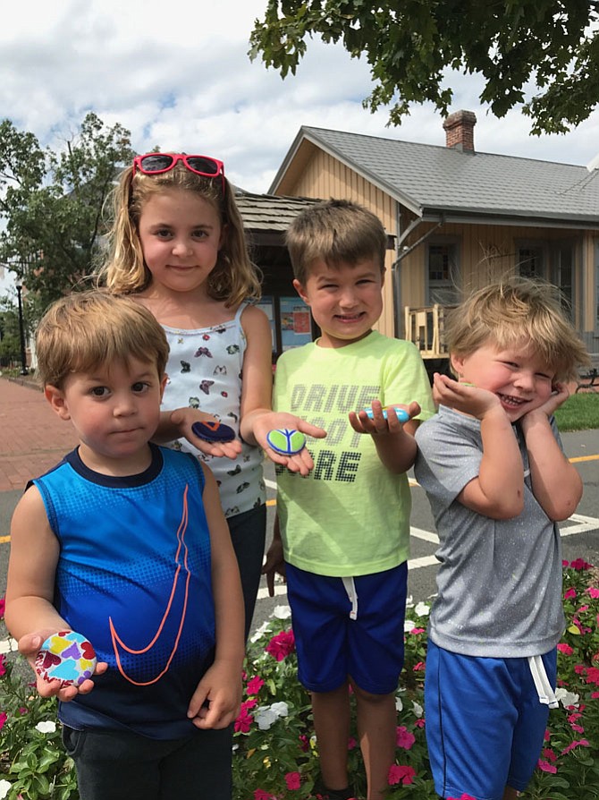 From left: After enjoying Farmers Market Fun Days produced by Parks and Recreation at the Herndon Town Square, Calvin Yetik almost 3, sister, Juliet, 6, and friends Connor Witaker 4, and his brother, Blake, 2, all of Reston, show off their painted rocks they are about to hide near the Herndon Depot Museum. 