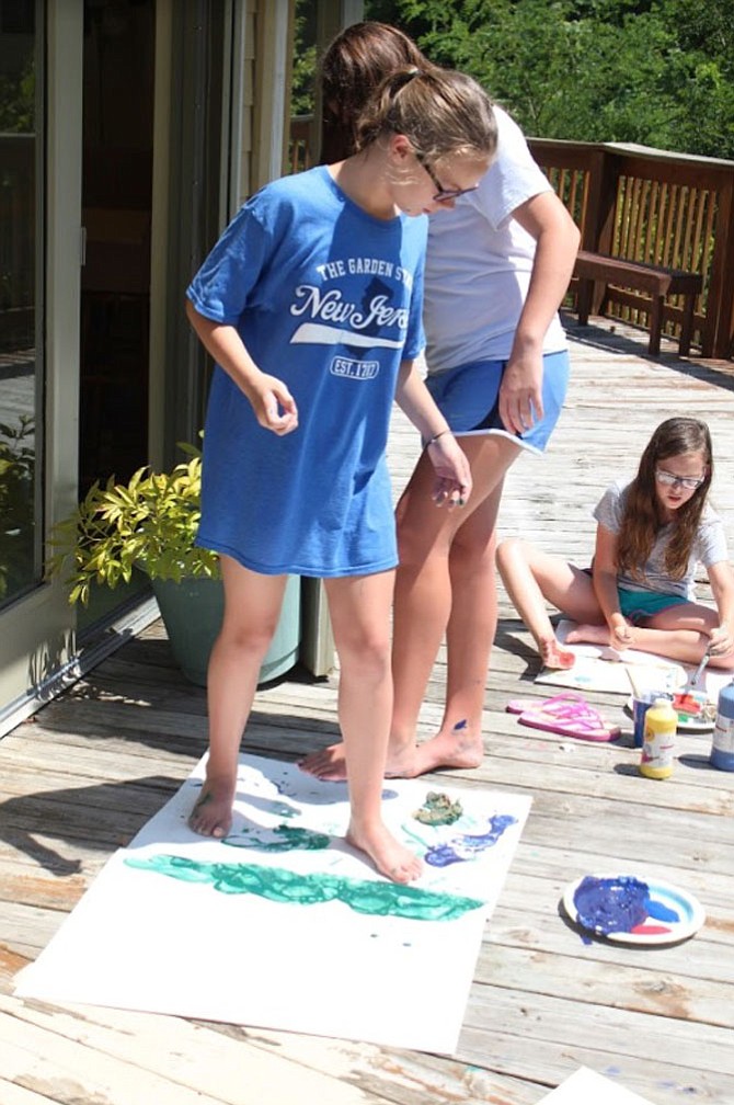 Studio Art campers paint with their feet for an art project at Summer Cove Camp, which was started by Burke native Megan Zinn, 22.

