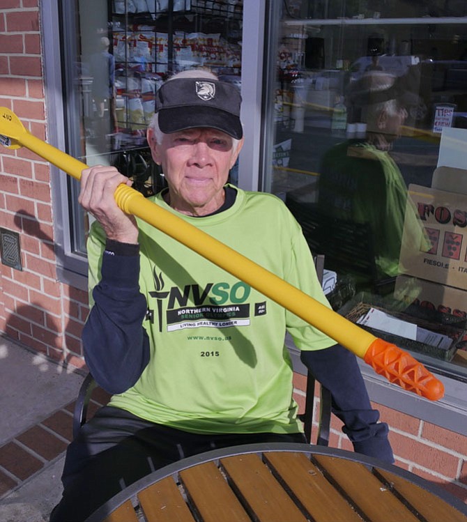 Charles Toftoy sits with his turbo-jav, a shorter and lighter version of the long javelin, which is illegal in Arlington. He will be participating in his "20th or so" Northern Virginia Senior Olympics in several sports including the cornhole toss, the 400-meter walk and his newest obsession, pickleball. 