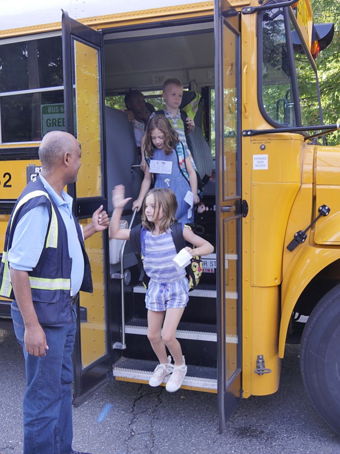 The school bus driver on route 607 opens the door, hops out of the bus and welcomes the children to the first day of school at Taylor Elementary with a high five. 