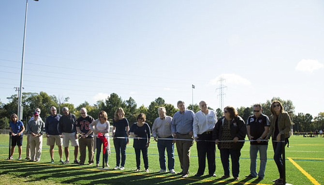 From left to right: Cindy Roeder, director of the Herndon Parks and Recreation Department; John Irish, chief program and project management for the Herndon Department of Public Works; Robert Walker, chair of the Herndon Architectural Review Board; Bill Ashton, Herndon Town Manager; Mark Martino, athletic services branch manager for the Fairfax County Department of Neighborhood and Community Services; Bill McKenna, Herndon councilmember; Lisa Merkel, mayor of Herndon; Jennifer Baker, Herndon vice mayor and councilmember; Signe Friedrichs, Herndon councilmember; Jeff Davidson, Herndon councilmember; John Foust, Dranesville District Supervisor; Lance Kilby, director of engineering for Burgess & Niple, an engineering and architectural firm; Jody Rameta, club administrator for Herndon Youth Soccer; Dave Bekenstein, president of Herndon Youth Soccer; and Sally Burns, vice president and director of travel for Herndon Youth Soccer.