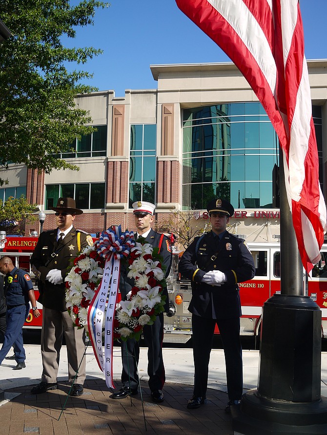 Lieutenant Laureano, Officer Vincent Ruggero of the ACPD, and Captain Ben O'Bryant, of the ACPD, stand behind the wreath. More than 100 Arlington residents, and many of the county’s emergency personnel and officials, came together at Courthouse Plaza on this Sept. 11 to remember the attack of 16 years ago.