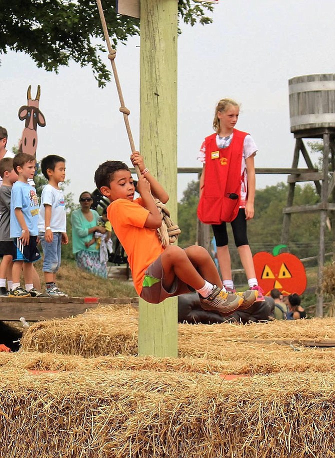 This boy is about to jump into some bales of hay at Cox Farms.