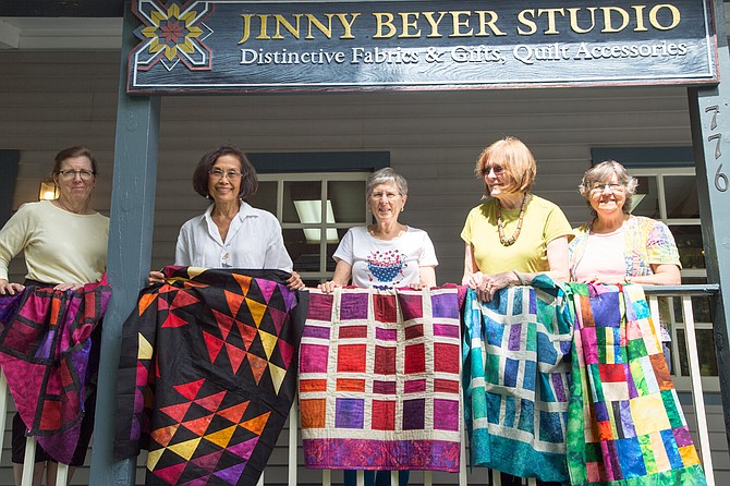 From left: Pat Blood, quilter, Carole Nicholas, Oakton resident and quilter, Marge Hughes, Great Falls resident and quilter, Jinny Beyer, owner of Jinny Beyer Studio, and Lura Alsalam, McLean resident and staff at Jinny Beyer Studio hold up quilts for donation to Hurricane Harvey Relief Tuesday at the Sew-in.
