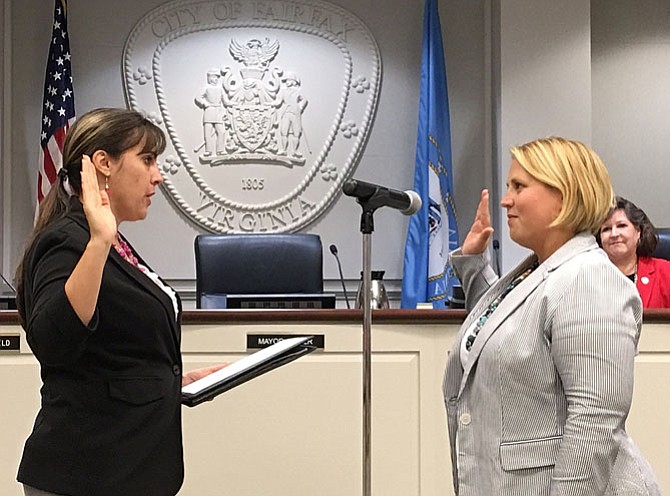 City Clerk Melanie Crowder (on left) administers the oath of office to Jennifer Passey.