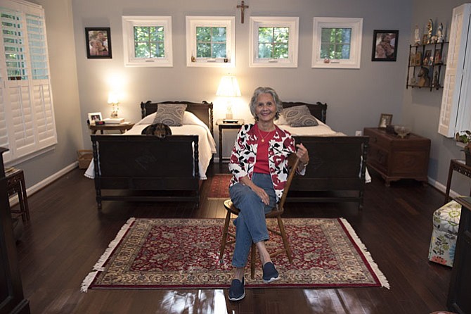 Lita Clark (who just turned 84) in the master bedroom of the in-law suite recently added to the home of her daughter Julia MacInnis and son-in-law, Jack. The room was designed to accommodate several heirlooms, including the twin beds under a course of Mi windows that assure privacy, yet allow abundant natural light.