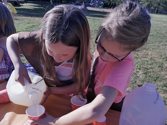 McKenzie Corry and Annabelle Wolff team up to pour cups of lemonade at 50 cents each for thirsty customers. Annabelle comments, “she sure is good at pouring.” Half of the Brownies were manning the bake sale and half were inside the school having a lesson about what it means to give to the community and the difference between need and want. They would combine experiences to earn their Philanthropist Badge.