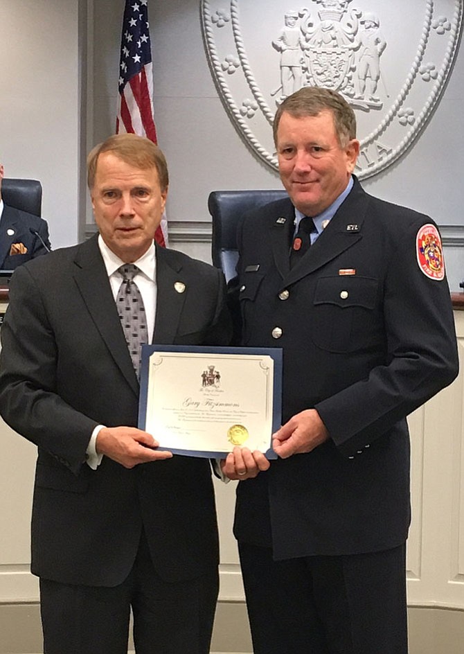 From left: Fairfax Mayor David Meyer presents a certificate commending firefighter/paramedic Gary Fitzsimmons for his lifesaving heroism. 