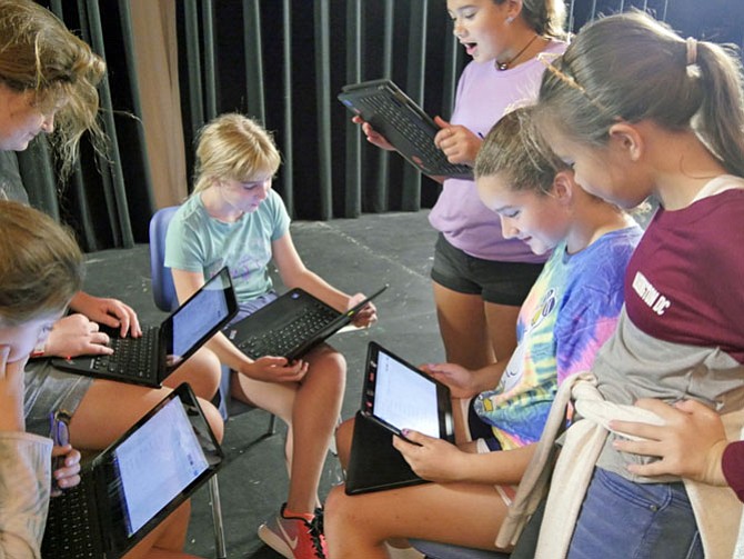 A group of middle school drama students hunch around a computer writing dialogue for their Greek tragedy based on protesting dress codes. They are just at the part where the goddess is cursed for wearing a toga that is too short.