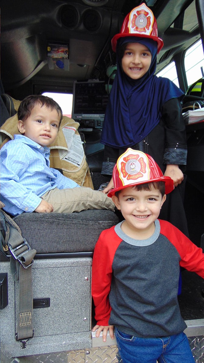 The Shah family of Lorton — Rabia, Rehaan, and Ayan — "ride" inside a fire truck during the Open House at Lorton Volunteer Fire Department Company #19 on Saturday, Oct. 14, 2017.