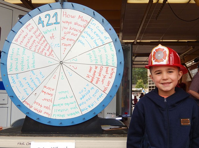 Jax Blevins, 7, stands by a game wheel filled with fire-safety questions.