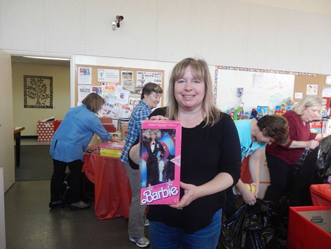 Laurel Cunnane, lead volunteer on the United Community Ministries’ Holiday Gift Room Project, with one of the donated toys in the Holiday Gift Room at United Community Ministries in the Alexandria area of Fairfax County. 
