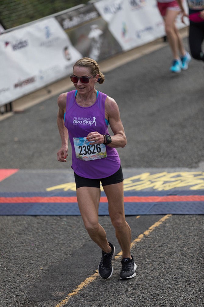 RunningBrooke founder Brooke Curran, shown at the finish line of the 2016 Marine Corps Marathon, will run again on Oct. 22 to raise money for Alexandria nonprofits focusing on children’s fitness.

