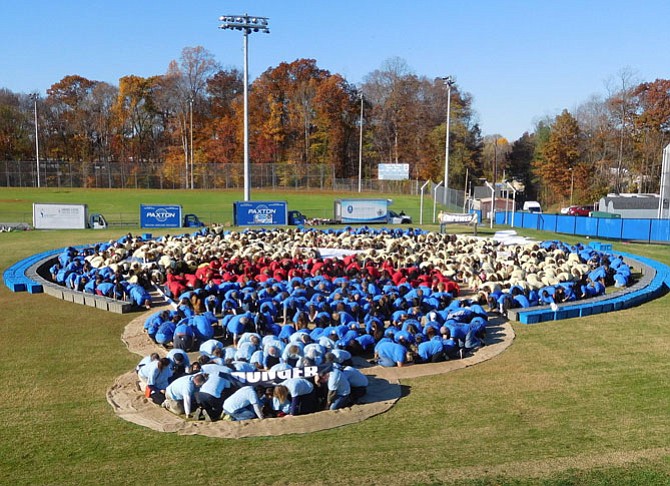 Participants crouch down according to the color of their T-shirts to create a previous year’s Complete the Circle design.
