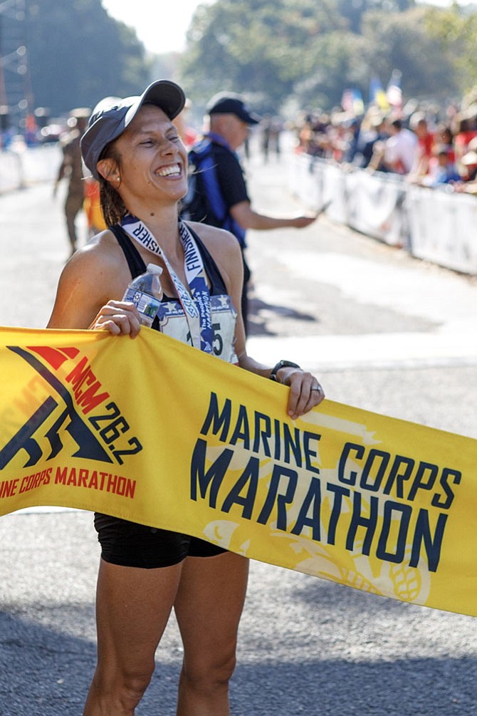 Sarah Bishop, 35, of Fairfax, celebrates holding the finish line tape after winning the women’s division of the Marine Corps Marathon with a time of 2:45:06.