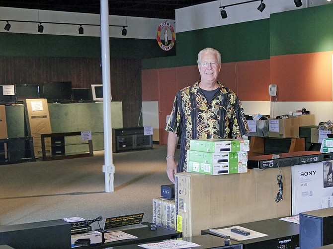 Ken Sickmen, owner of family-run Belmont TV, stands in a nearly empty showroom after announcing a closeout sale a week ago. Sickmen is closing the business after 75 years. 