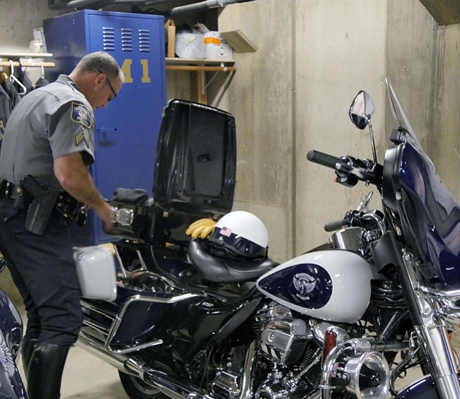 Sgt. Charles “Chuck” Seckler checks out his 950-pound Harley Davidson before heading out to major intersections where “we can’t ticket fast enough.”