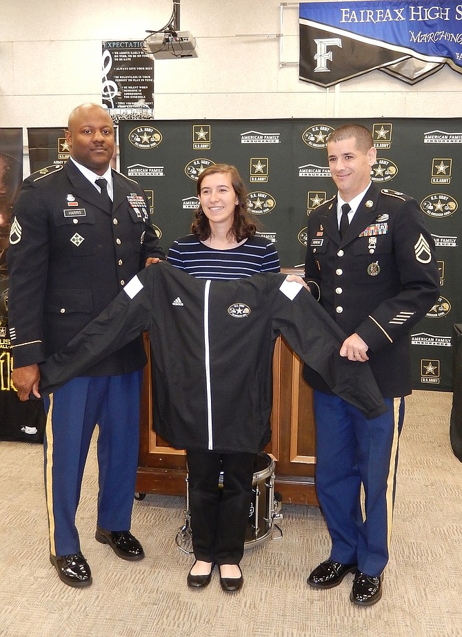 Fairfax High’s Sara Young receives her Army All-American Band jacket from (from left) Staff Sgts. Allen Harris and Adam Moreau.