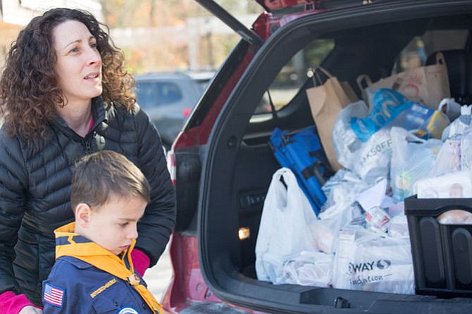 Candice Holt, a stay at home mom and Great Falls resident and her son, Ned Holt, 7, a Cub Scout in Pack 55 arrived with her SUV filled to the brim with grocery bags of food for the food drive Saturday in Great Falls. 
