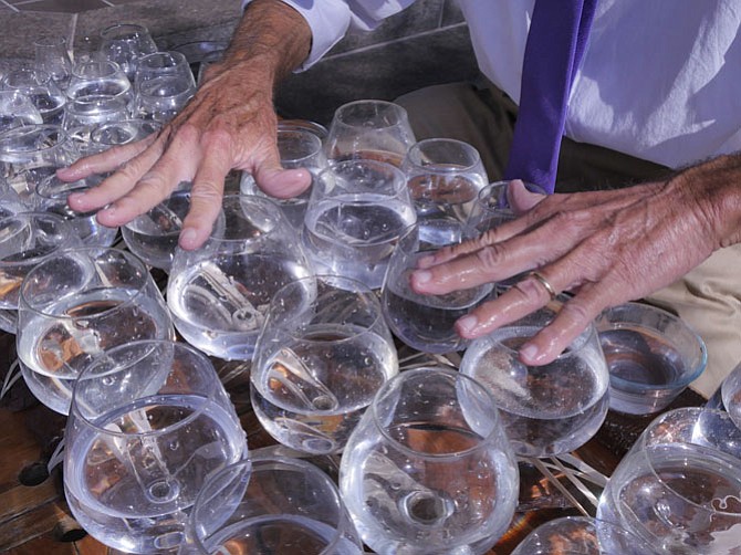 Jamey Turner uses different fingers to get the chords and the overtones on the glass harp that he plays at the corner of King and Union.