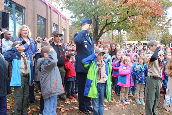 Teachers, parents, and students salute the flag as the "Star-Spangled Banner" played.