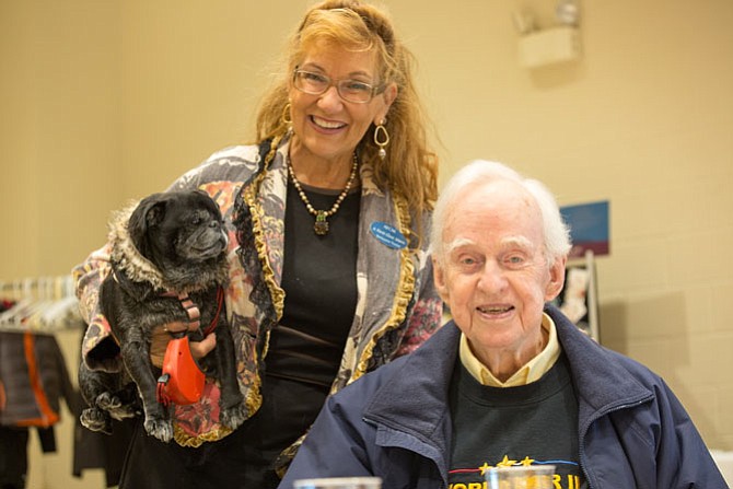 Beckyanne Theriot, the owner of “A First Class Move,” a local moving company that sponsored the event and Richard Kirkland, an Air Force WWII and Korean War veteran. Theriot brought her pug Pearl to the Thanksgiving meal at Our Lady of Good Counsel Church on Tuesday, Nov. 14 in Vienna. 